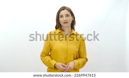 Woman smiling looking at camera isolated on white background.Portrait of beautiful woman in yellow shirt. Royalty-Free Stock Photo #2269947615