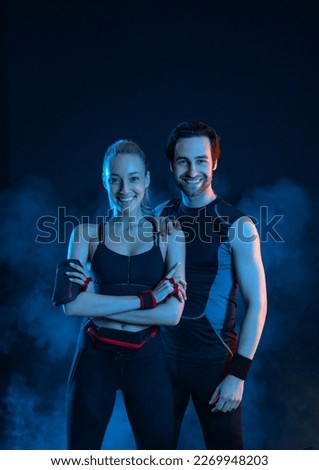 Download photo for advertising a fitness club in social networks. Fitness Influencers. Fitness couple at home. Cover for sport motivation music. Fit man and woman at the gym on black background.