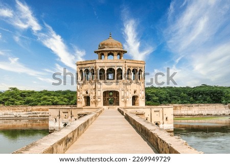 The exquisite minaret and tranquil lake at Hiran Minar, a UNESCO World Heritage Site, in Sheikhupura, Pakistan, create a truly enchanting scene.  Royalty-Free Stock Photo #2269949729