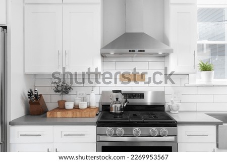 A kitchen detail shot with white cabinets, stainless steel appliances, granite countertops, and a subway tile backsplash. Royalty-Free Stock Photo #2269953567