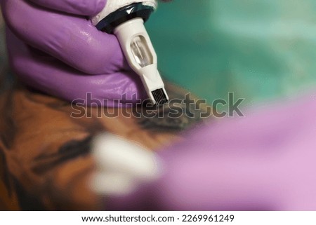 Ink artist making a tattoo with professional machine Royalty-Free Stock Photo #2269961249