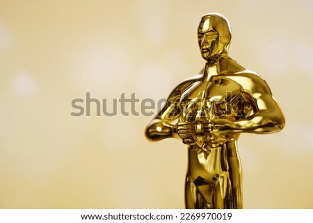 Hollywood Golden Oscar Academy award statue on golden background. Success and victory concept.
