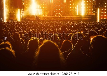 Silhouette of a happy crowd with hands up during a big rock concert Royalty-Free Stock Photo #2269971917