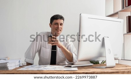 Business accountant bookkeeper in office looking at documents and working with laptop.