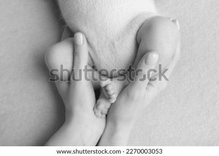the legs of the child in mothers hands black and white photo