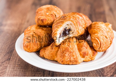 bite croissants with chocolate on a white plate, french kitchen, breakfast