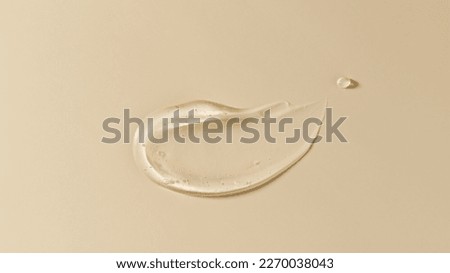 Cosmetic transparent gel serum swatch with bubbles isolated on beige background. Texture moisturizing gel of hyaluronic acid closeup. Face or body natural skin care products Royalty-Free Stock Photo #2270038043
