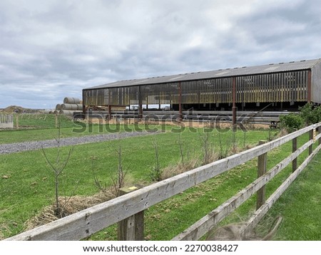 Picture of a farm barn and open field taken on a cloudy overcast day