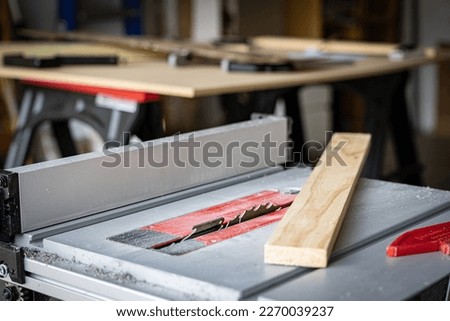 Piece of wood placed on surface of a table saw ready for a carpenter to measure and cut it Royalty-Free Stock Photo #2270039237