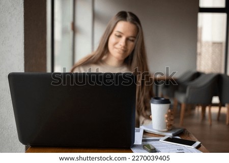 Young women working with laptop while sitting at café