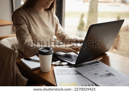 Young women working with laptop while sitting at café