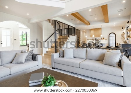 Elegant and spacious open concept interior rooms new construction with concrete floors designer decor wood beams on ceiling classic style Royalty-Free Stock Photo #2270050069