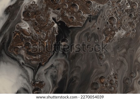 Flow pour wave oil and acrylic color painting blot and drop wall. Abstract swirl black and bronze texture background.