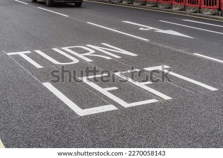 Turn Left markings on freshly paved road, infrastructure and travel and transport concept illustration.