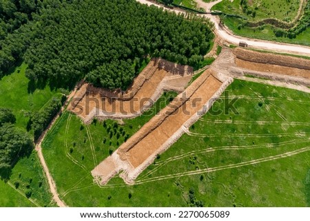 Removal of the top layer of earth overburden for the development of a sand pit, aerial view Royalty-Free Stock Photo #2270065089