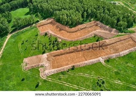 Removal of the top layer of earth overburden for the development of a sand pit, aerial view Royalty-Free Stock Photo #2270065091