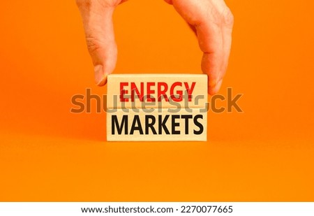 Energy markets symbol. Concept words Energy markets on wooden block. Beautiful orange table orange background. Businessman hand. Business energy markets concept. Copy space.