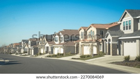 Suburban homes in a row with empty driveways Royalty-Free Stock Photo #2270084069
