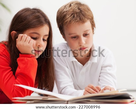 Brother and sister doing their homework together. Elementary age.