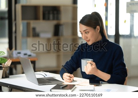 Businesswoman using laptop at cafe while drinking coffee, Relaxing holiday concept.