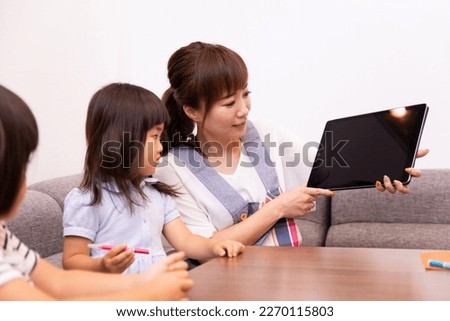Child and woman looking at tablet