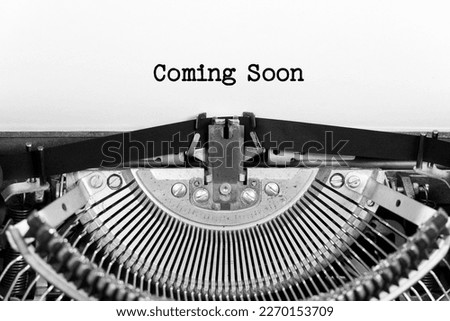 Coming Soon phrase close up being typing and centered on a sheet of paper on old vintage typewriter mechanical Royalty-Free Stock Photo #2270153709