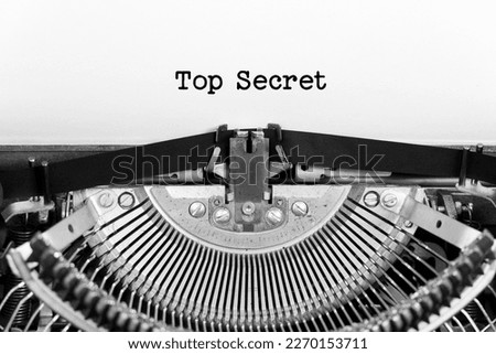 Top Secret phrase closeup being typing and centered on a sheet of paper on old vintage typewriter mechanical Royalty-Free Stock Photo #2270153711