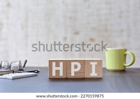 There is wood cube with the word HPI. It is an acronym for Human, Performance, Improvement an eye-catching image.