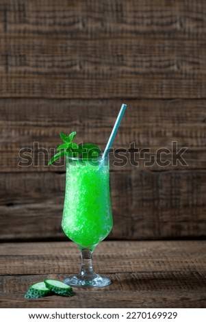 granite dessert, frozen juice of fresh cucumber and mint on a wooden background, minimalism. Summer coolness, tonic ice cocktail, green drink, St. Patrick's day