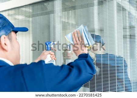 A cool Asian janitor cleaning Royalty-Free Stock Photo #2270181425