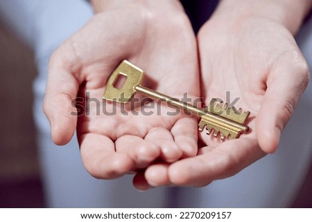  Close up of human hand holding golden key