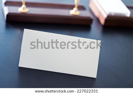 White triangular sign for the label standing on a table. Room for you text.