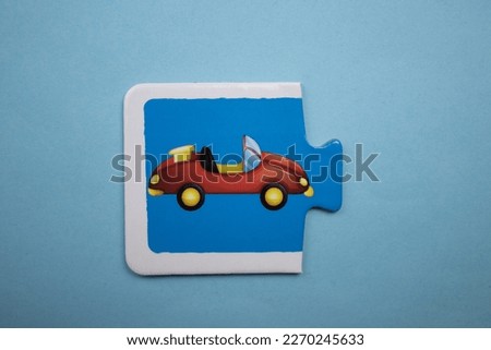 Educational puzzle with colorful pictures of cars placed on a blue background.