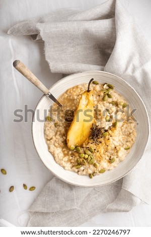 Porridge oatmeal with baked pear, pumpkin seeds, sesame and honey 