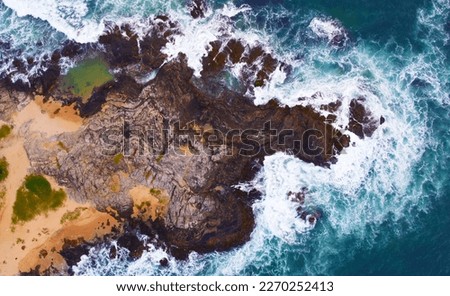 Aerial view of the sea rocks cliffs in the ocean. Beautiful sea wallpaper for tourism and advertising. Stormy landscape, drone photo