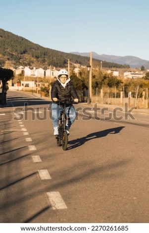 Hispanic female commuter on e-scooter, cruising a city block