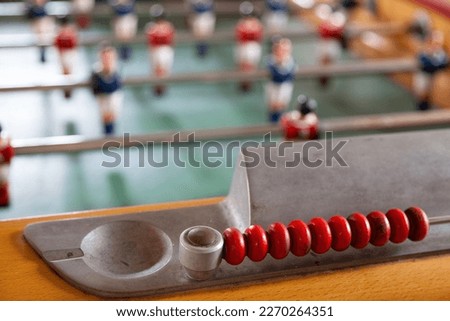 Table football, commonly called fuzboll or foosball (as in the German Fußball "football") and sometimes table soccer, is a table-top game that is loosely based on association football. Royalty-Free Stock Photo #2270264351