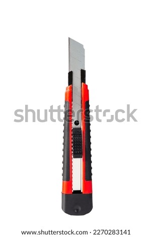 The red stationery knife isolated on white background.  Cutting tool with blades on a white background. Technology concept. 
