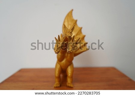 golden dragon ghidorah isolated on white background. On wooden table