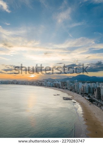 Vertical aerial image of the amazing sunset at Praia do Morro in the summer of Guarapari, Espírito Santo, Brazil.