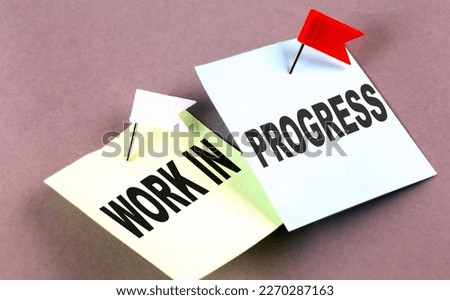 WORK IN PROGRESS text on sticky on grey background