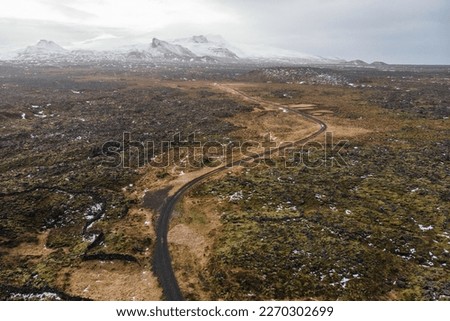 a lonely road between lava fields  taken from a drone
