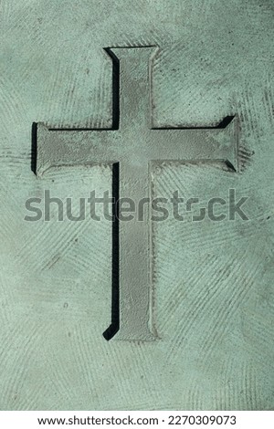 A beautiful simple Christian cross etched into an aged copper metal plate.