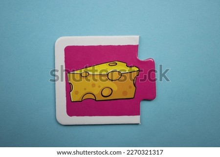 Educational puzzle with colorful cheese pictures placed on a blue background.