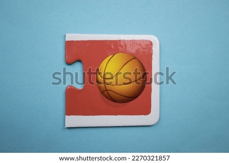 Educational puzzle with a colorful basketball picture placed on a blue background.