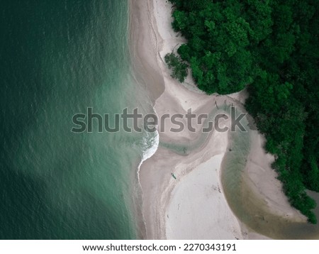 Aerial drone photo in Costa Rica, view of the river flowing into the pacific ocean from the jungle into the sea