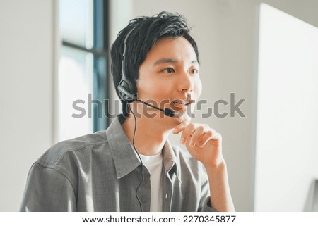 Young business man wearing a headset for an online meeting. Royalty-Free Stock Photo #2270345877