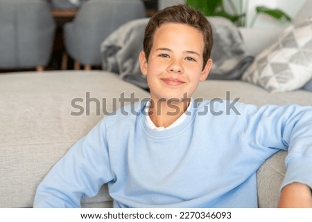 Male school kid, schoolchild, young guy with neck-length brown hair looking at camera. Close up of face, front view. Childhood concept Royalty-Free Stock Photo #2270346093