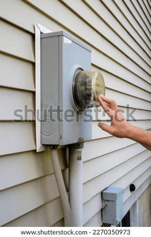 Man looking at electricity meter at home. Electric power box meter for home use, utility bill . 