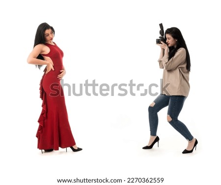 woman photographer taking photos in studio on white background, wearing jeans and brown leather jacket. photo camera session